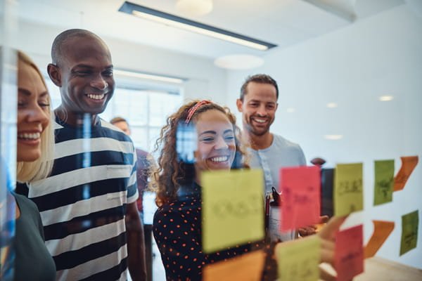People looking at a wall of sticky notes