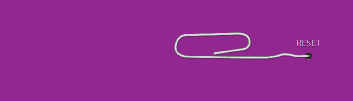 A straightened paperclip being pushed into a pin-sized reset button.