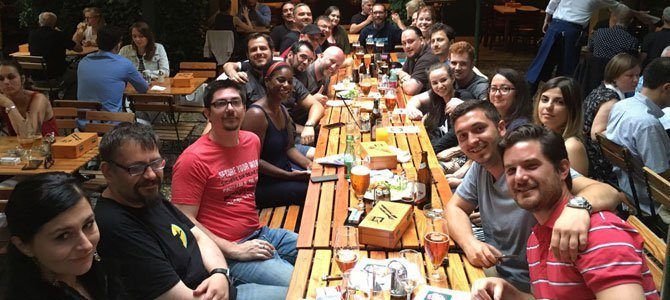 Group photo with many members of the WPMU DEV team after eating dinner together, sitting at a long table.